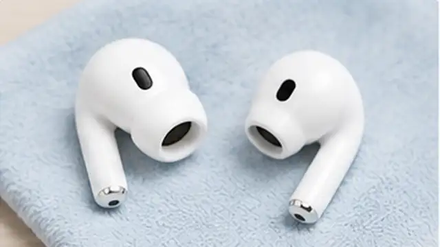 Clean earbuds, silicone tips, and an open charging case air-drying on a cloth before reassembly.