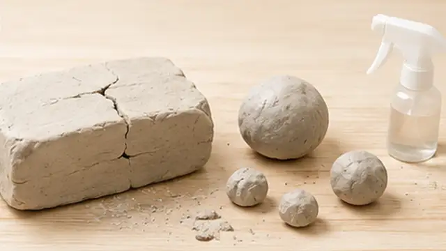 Person inspecting a crack in an air-dry clay bowl and removing loose clay crumbs.
