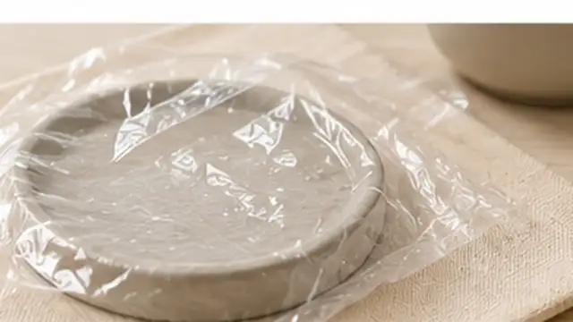 Repaired air-dry clay bowl drying slowly under a loose plastic cover away from direct heat.